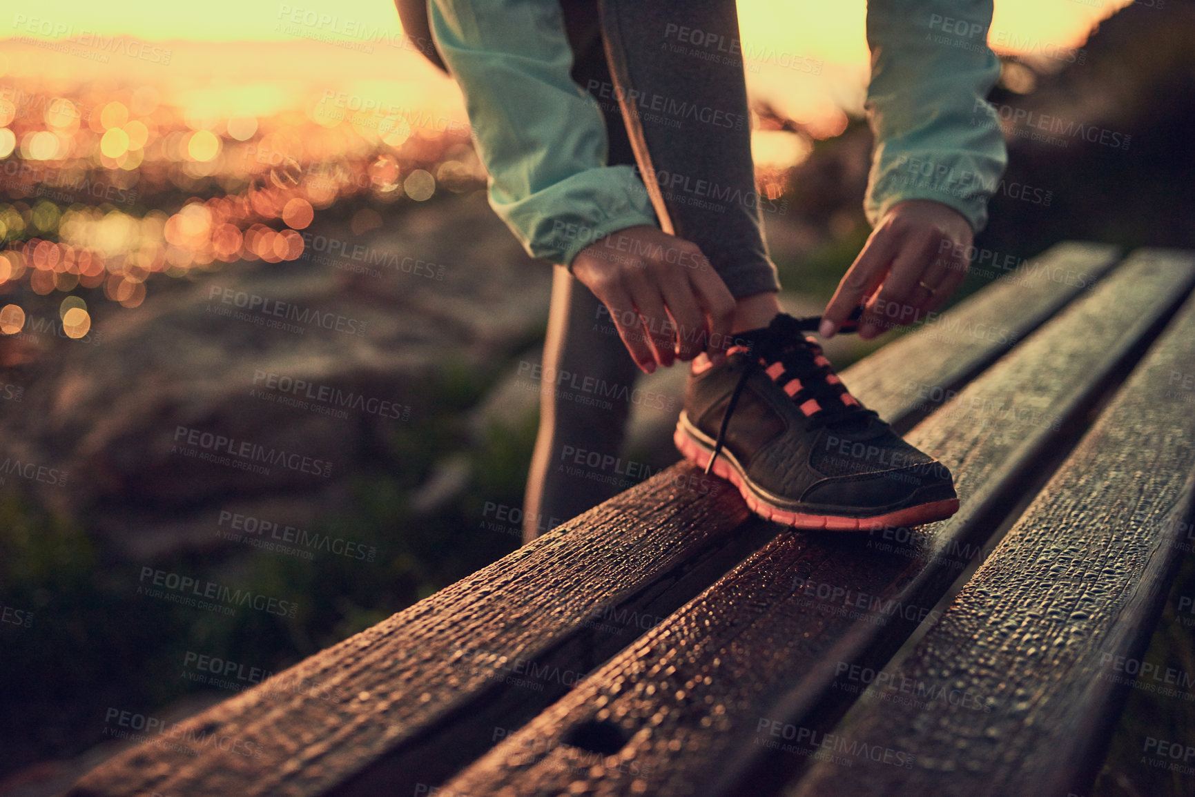 Buy stock photo Shot of an unrecognizable woman tying her shoe laces before a run