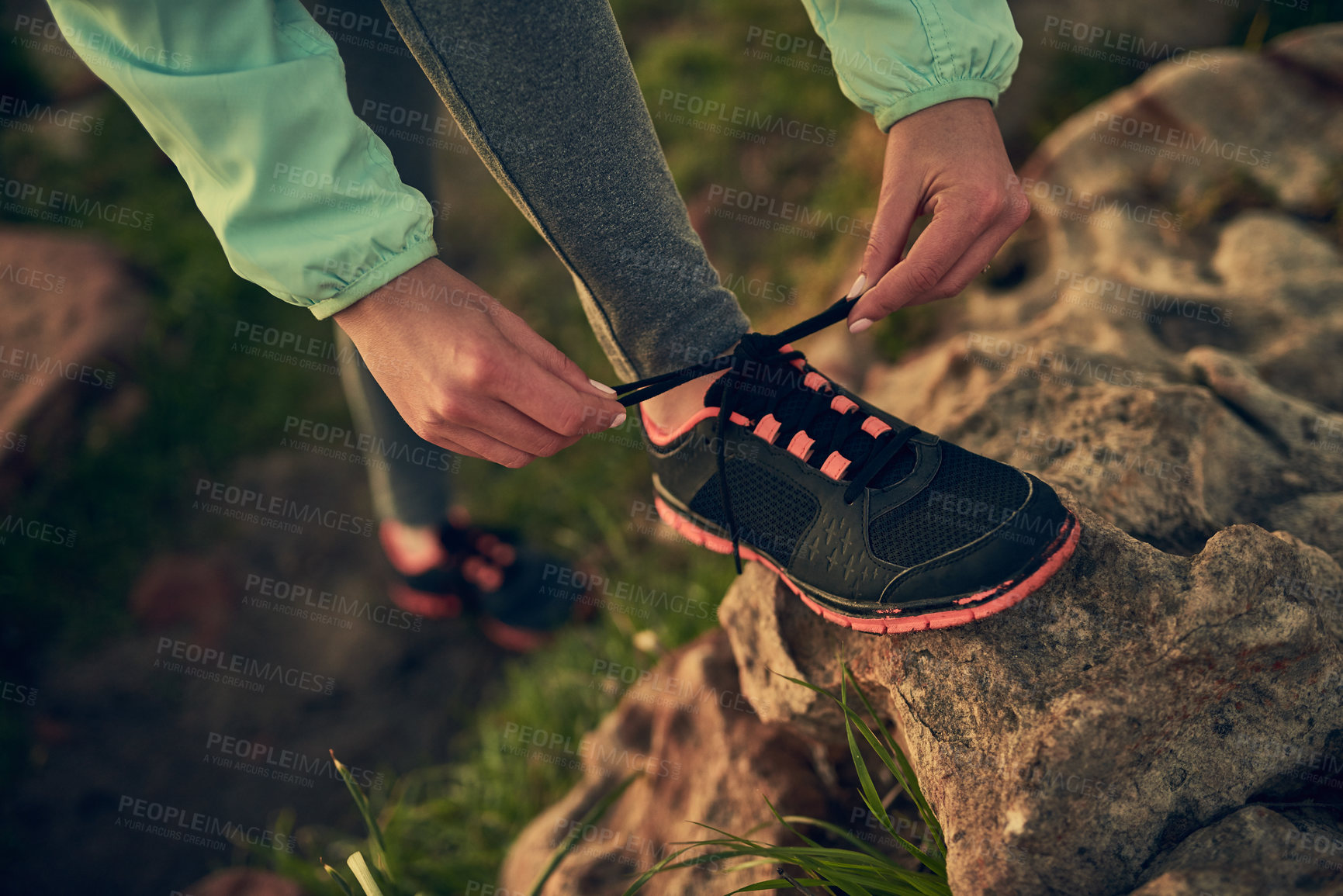 Buy stock photo Shot of an unrecognizable woman tying her shoe laces before a run