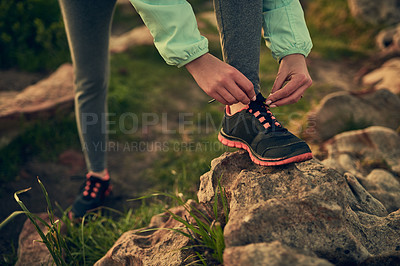 Buy stock photo Shot of an unrecognizable woman tying her shoe laces before a run