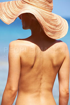 Buy stock photo Rear view of topless young woman in sun hat standing and tanning