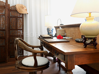 Buy stock photo A luxurious table and chair in a hotel room with antique wooden furniture. A bedroom with a vintage design with, books, a hat, and lambs. Traditional and historic lodge for a holiday or vacation