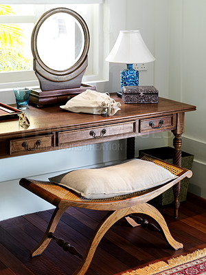 Buy stock photo Beautiful wooden dressing table and mirror in a hotel bedroom. Vintage furniture in a modern hotel by a window. Antique bench and dresser with a mirror on top in a room of an old school resort