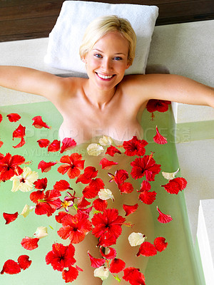 Buy stock photo Attractive young woman in a bath with floating petals