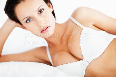 Buy stock photo Young busty woman in white lingerie lying on the bed