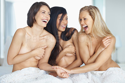 Buy stock photo Laughing young naked women in bed covering their breasts