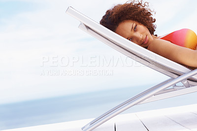 Buy stock photo Portrait, sunbathing and black woman relax at beach for travel, summer or vacation on blue sky background. Face, tanning and beautiful girl relaxing by the ocean, content and happy on Caribbean trip