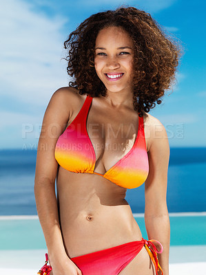 Buy stock photo Portrait of happy and sexy woman in a bikini with curly hair at the beach in summer. Beauty model with a smile and ocean, water and blue sky in the background while on holiday, vacation or travel