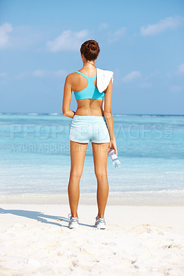 Buy stock photo Rear view of fit young woman standing while facing ocean