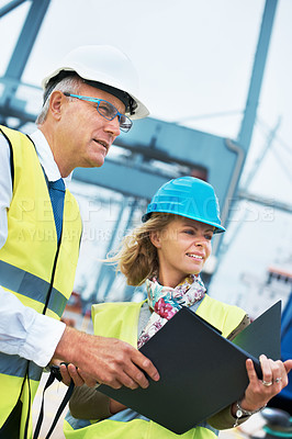 Buy stock photo Two engineers discussing planning on a site while looking away