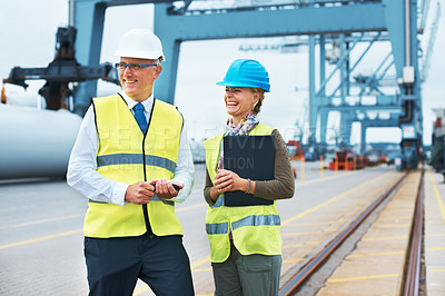 Buy stock photo Two dock workers standing together and smiling while on the job