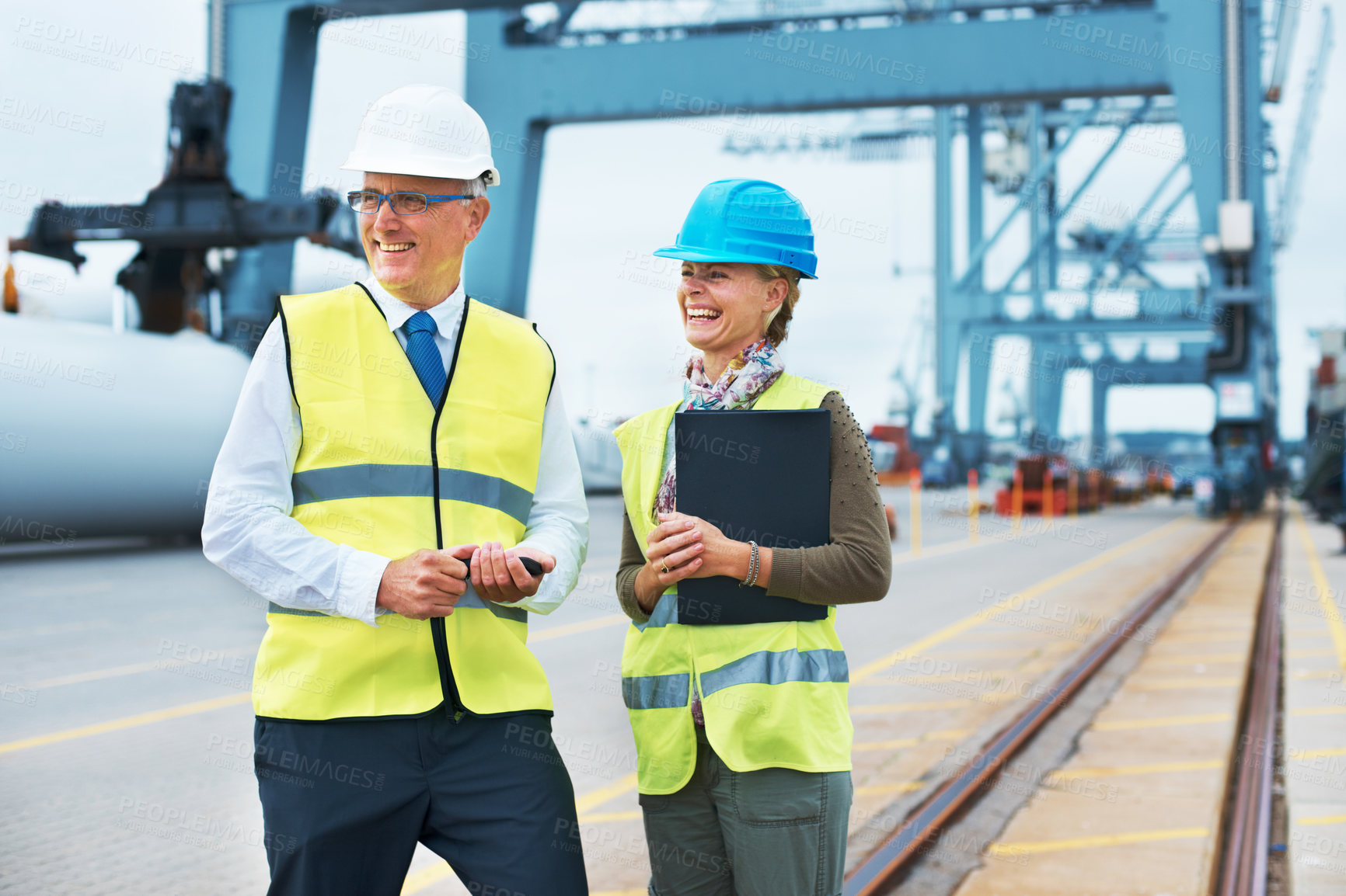 Buy stock photo Two dock workers standing together and smiling while on the job
