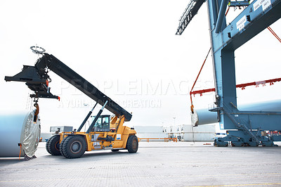 Buy stock photo A loader in a vehicle handling cargo in an industrial area. in industry a loader using vehicle to load shipment. Distribution products. Delivery, Logistics and Transportation