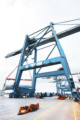 Buy stock photo Cranes and vehicles on the dock at a shipyard. Cranes on a cargo ship loading shipping containers at an industrial port. Logistics and transportation industry import and exporting international goods