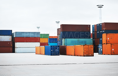 Buy stock photo Bright and colourful storage container stock on a harbour dock ready for import and export. Freight delivery cargo for inspection by customs before shipping for distribution. Maritime logistics