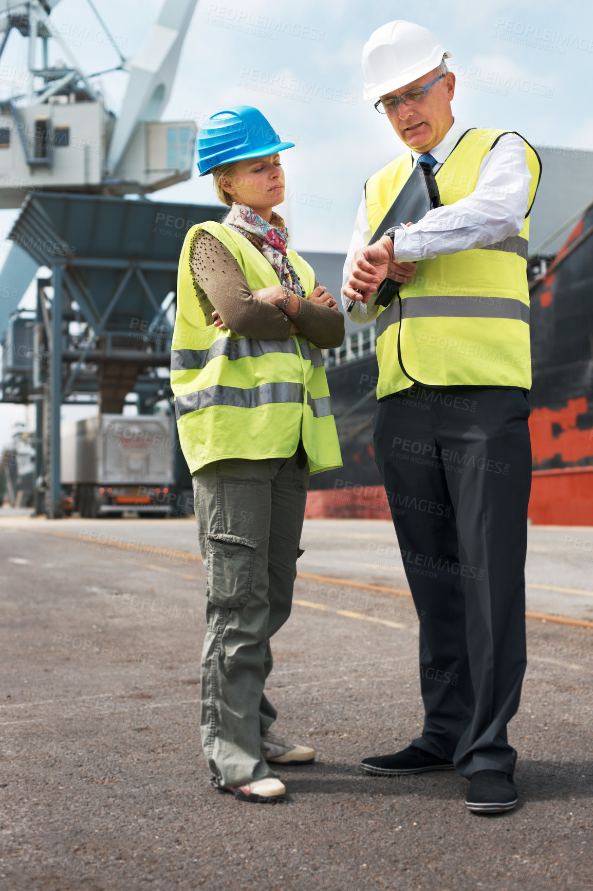 Buy stock photo Two engineers discussing planning on a site while in the shipyard