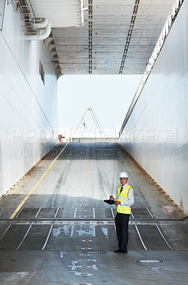 Buy stock photo A smiling foreman taking notes while standing on a ramp
