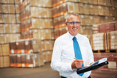 Buy stock photo A storage warehouse manager standing in the factor amidst many boxes