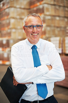 Buy stock photo A storage warehouse manager standing in the factor amidst many boxes