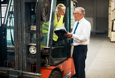 Buy stock photo A manager giving orders to an employee who's sitting on a forklift.