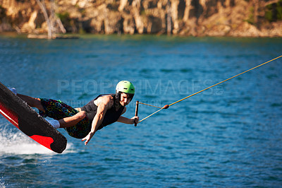 Buy stock photo Surfing, wakeboard and extreme sports with man in lake for action, summer break and travel vacation. Wave, adrenaline junkie and fitness with guy skiing on river for health, adventure and speed