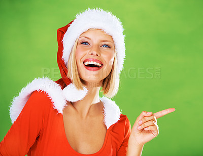 Buy stock photo Wow, Christmas and woman in studio pointing to marketing, advertising or branding space with a smile. Green background, mockup and happy girl in a santa hat showing a discount announcement deal offer