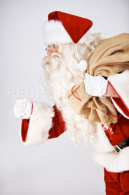 Buy stock photo Santa Claus running with a sack of presents on his back - isolated on white