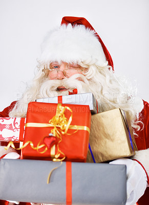 Buy stock photo Wink, Christmas gifts and portrait of Santa Claus in studio on white background. Xmas, costume and man with glasses holding pile of presents for happy December holiday celebrations or festive party