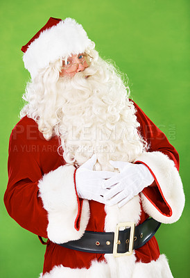Buy stock photo Santa claus, celebration and belly in studio portrait for Christmas holiday, festive season or gift giving. Male person, stomach full or character on green background on vacation, happiness or winter