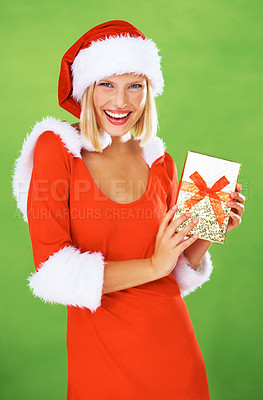 Buy stock photo Woman, Christmas and holding gift box in studio holiday giving, festive vacation or smile. Female person, red outfit and portrait for present or excited celebration, winter break on green background