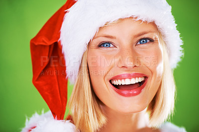 Buy stock photo Face, beauty and christmas with a model woman in studio on a green background for festive celebration. Portrait, happy and smile with an attractive young female wearing a santa hat in the holidays