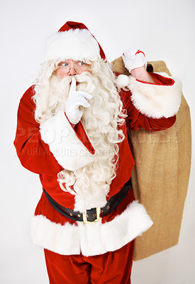 Buy stock photo Secret, quiet and santa with christmas gift sack for silent holiday present giving in red suit. Silence of santa claus model holding festive gifts bag in studio with white background thinking.
