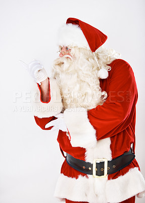 Buy stock photo Father Christmas in studio pointing to white background for marketing, branding or advertising mockup space. Product placement, santa claus or old man shows retail sales discount offer or promo deal