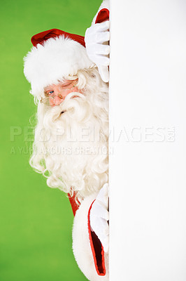 Buy stock photo Santa claus, hiding and wall portrait for Christmas celebration, mockup space or wink. Male person, secret peek and emoji face for festive seasons or holiday, green studio background or signboard
