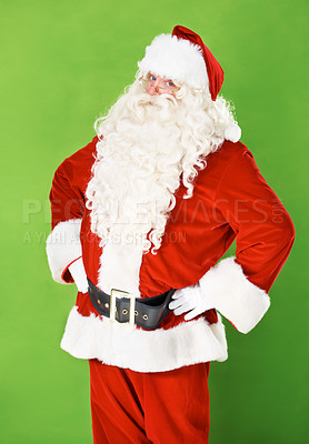 Buy stock photo Santa claus, hands and hips in studio portrait for holiday celebration, festive season or gift giving. Father Christmas, face and costume suit for winter vacation fun, on green background for joy