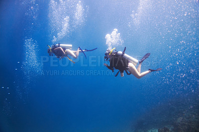 Buy stock photo Friends, swimming and scuba diving for underwater adventure, explore ocean and tropical holiday or vacation. Sports people, tourist or diver with bubbles, blue water and search for sea life or coral