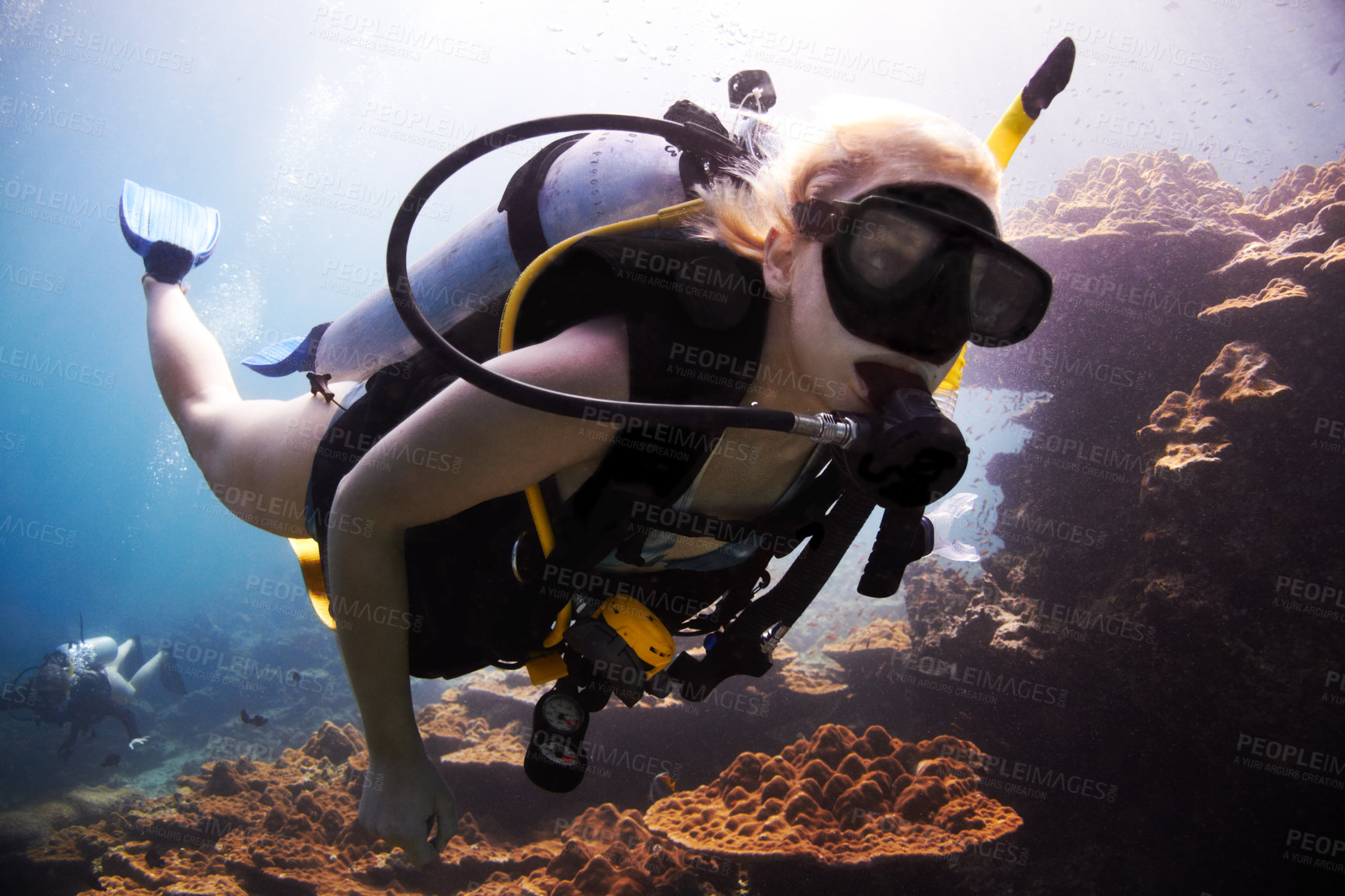 Buy stock photo Female scuba diver closely passes over a coral reef