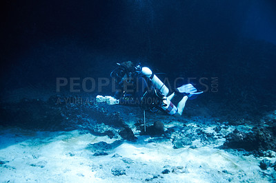 Buy stock photo Male scuba diver floating just off the ocean bottom - Deep ocean diving