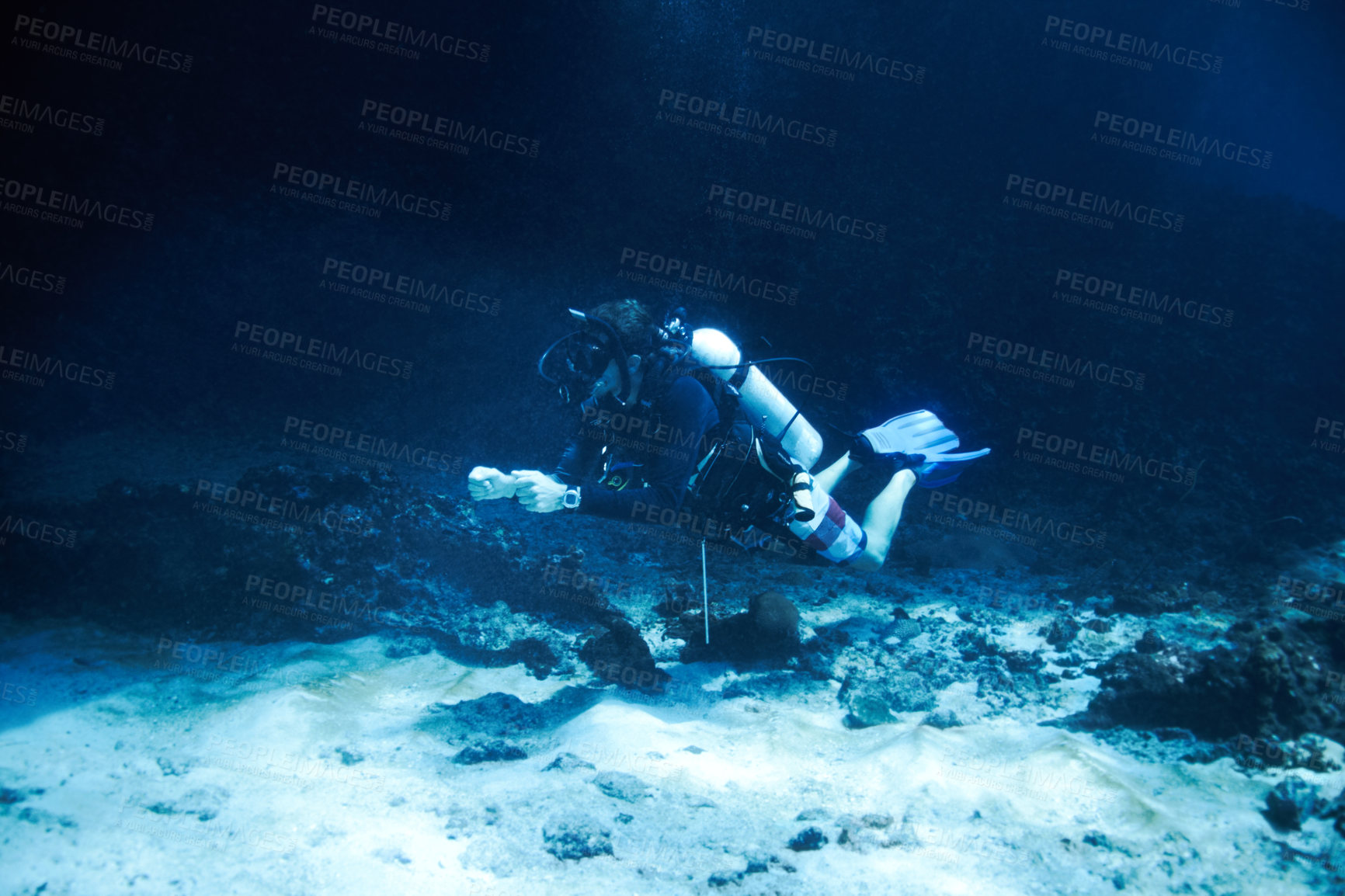 Buy stock photo Male scuba diver floating just off the ocean bottom - Deep ocean diving