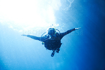 Buy stock photo A scuba diver descending towards you with her arms wide open - Copyspace