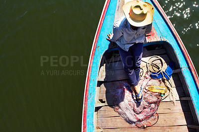 Buy stock photo Thai fisherman waiting patiently on his longtail boat - Thailand