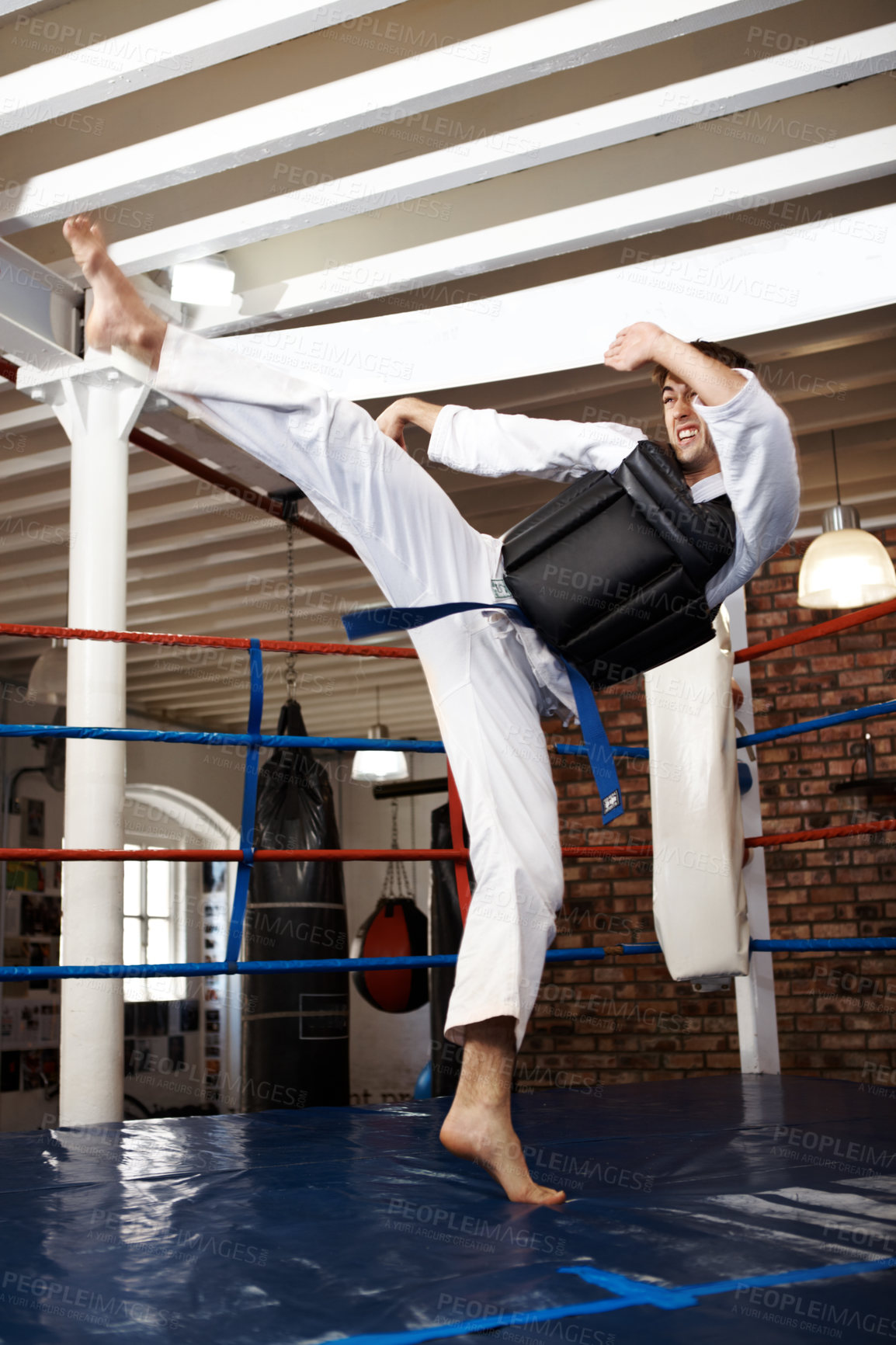 Buy stock photo Man, karate and high kick in training, self defense or jiujitsu for martial arts or fighting match. Male person, athlete or fighter in MMA boxing, muay thai or fitness practice at dojo or gym ring