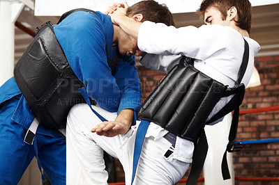 Buy stock photo Cropped shot of two martial artists sparring in the ring