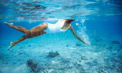 Buy stock photo Underwater, summer and a woman swimming in the ocean for travel, freedom or adventure in tropical nature. Sea, swimwear and a person diving to explore or discover a deep blue wilderness environment