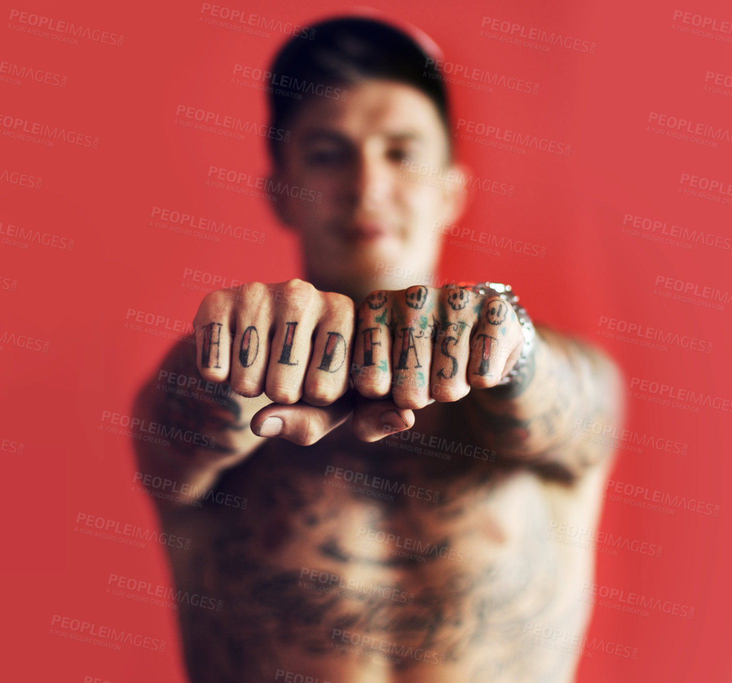 Buy stock photo Fist, tattoo or blurred man in studio isolated on red background with unique, cool or artistic creativity. Zoom, rebel or portrait of trendy macho person showing hands or knuckles with ink or tattoos