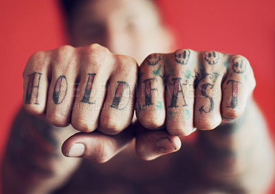 Buy stock photo Closeup shot of man showing the tattoos on his fingers against a red background