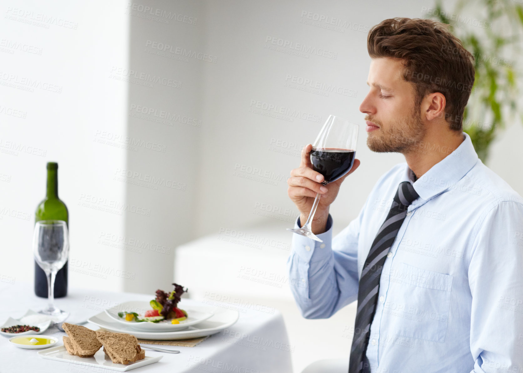 Buy stock photo Attractive young man appreciating the scent of a good wine in a restaurant