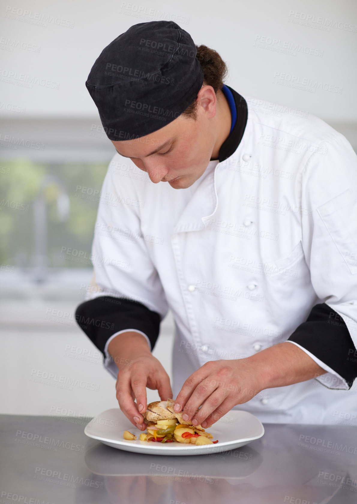 Buy stock photo Young chef preparing a chicken dish in a kitchen - Fine Dining