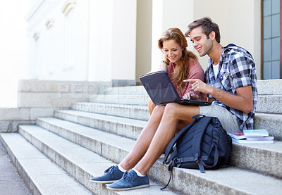 Buy stock photo Male and female student on the steps of their university sharing some study advice
