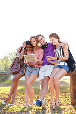 Buy stock photo Happy, hug and friends in a park with tablet for social media, streaming or music subscription search. Students, diversity and gen z group outdoor bond, relax or check digital app for meme or chat
