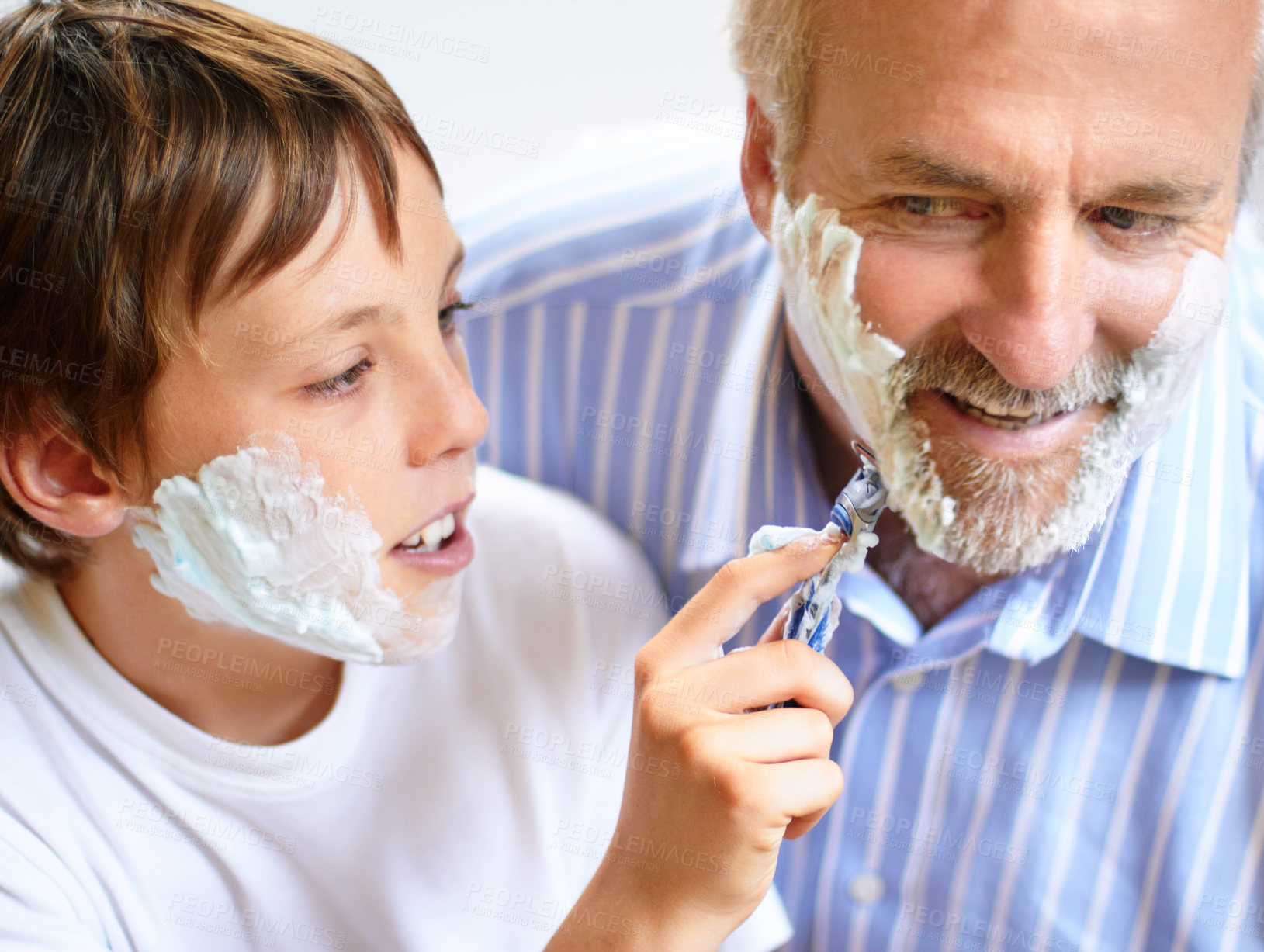 Buy stock photo Shot of a boy shaving his father's beard